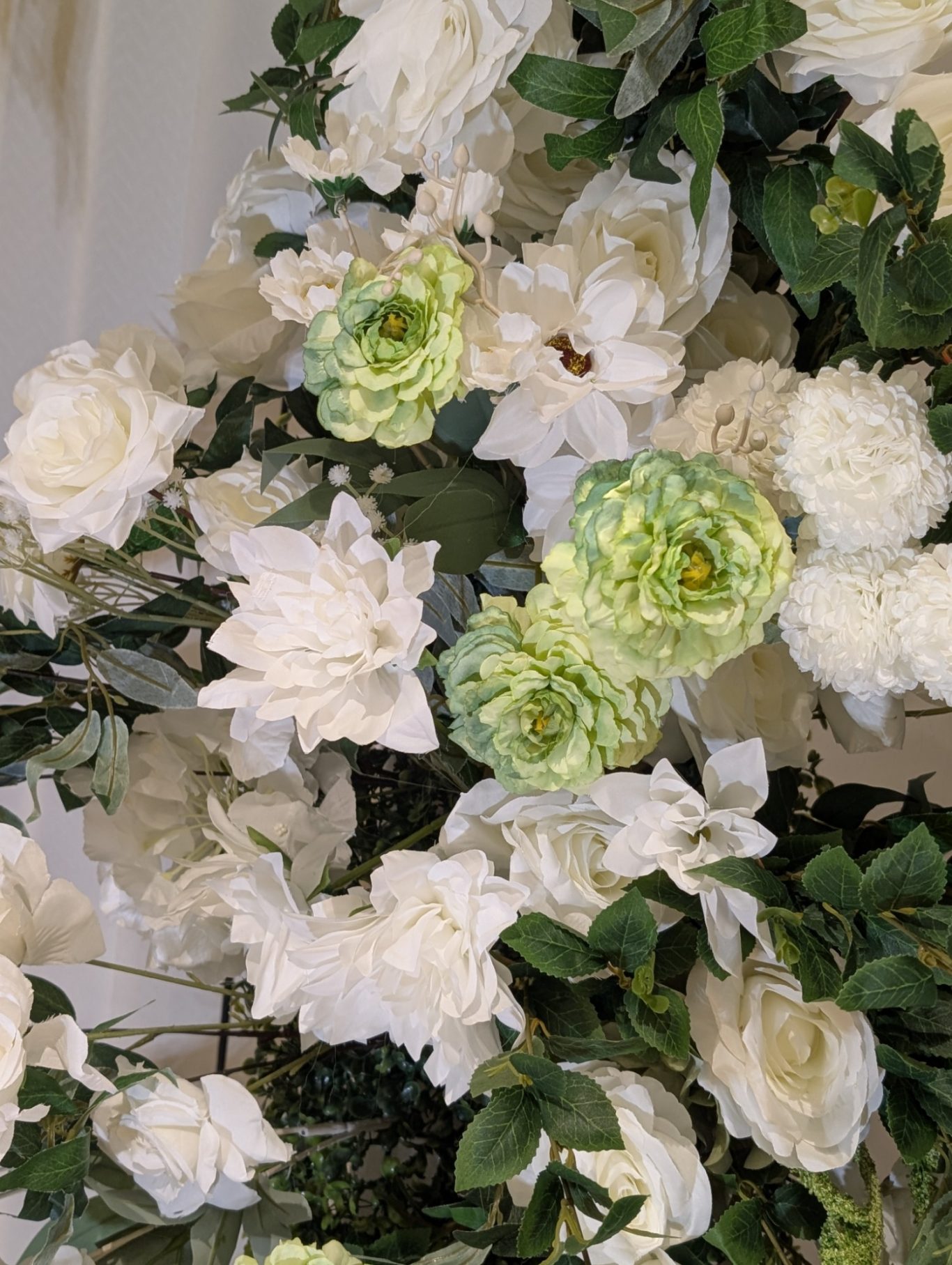 Grace - Detail A bouquet of white and pale green flowers with lush green foliage.